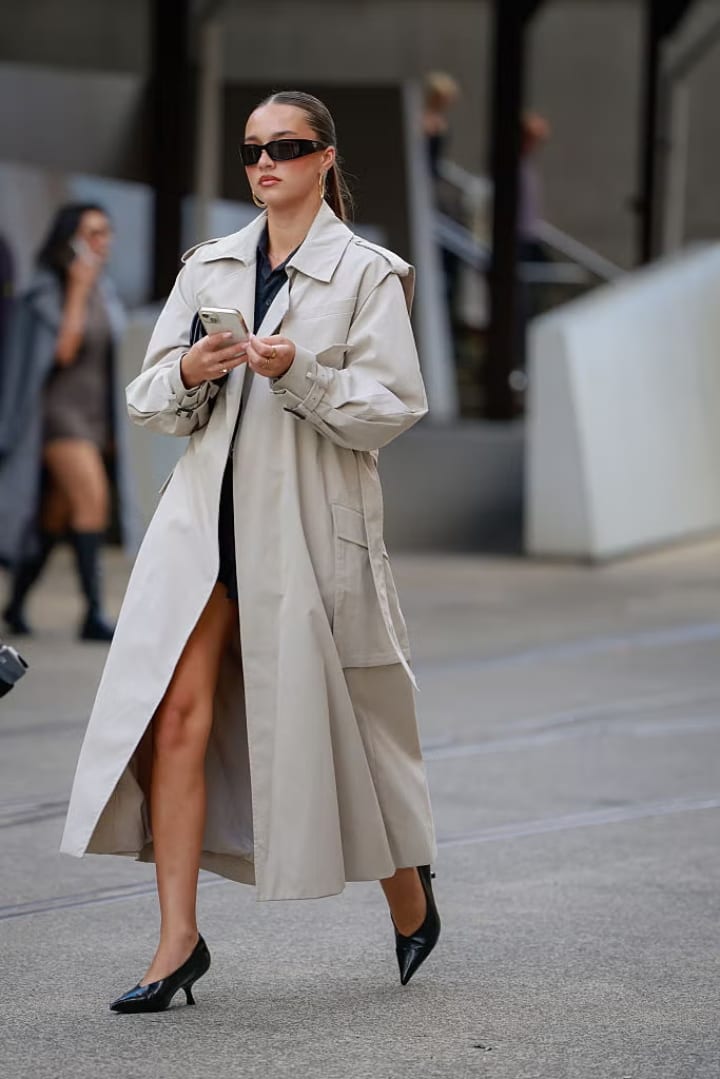 girl wearing a trench coat and sunglasses