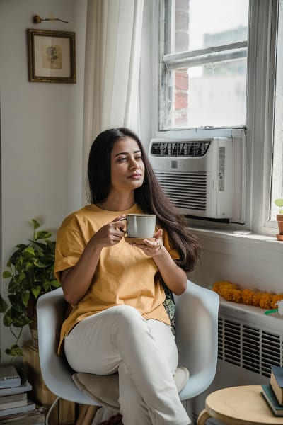 girl sitting in front of the air conditioner