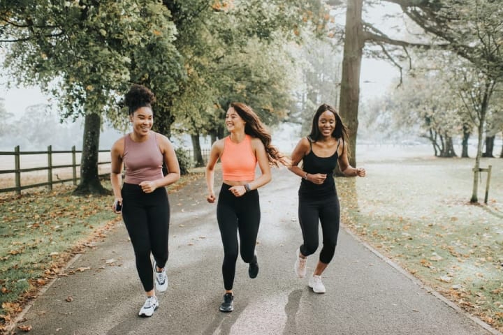 group of girl friends running in the park