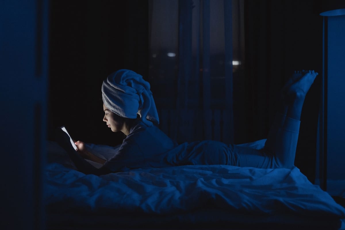 woman watching something in bed at night