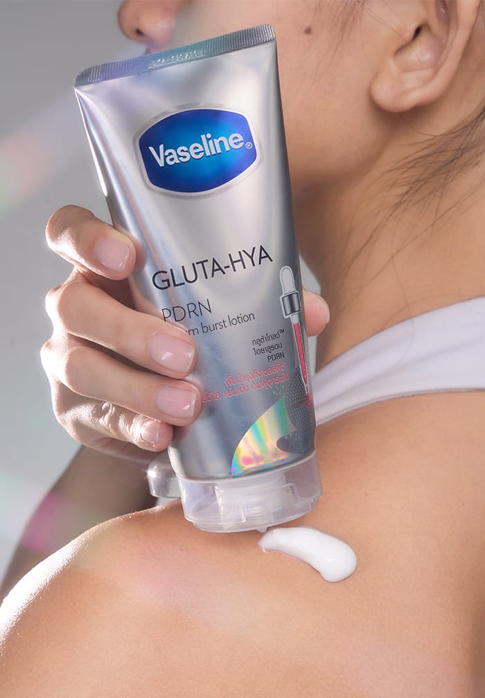 Woman applying lotion on her shoulders